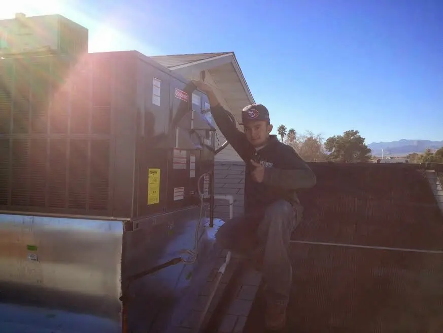 HVAC technician performing AC Tune-Up on a rooftop unit in Florin