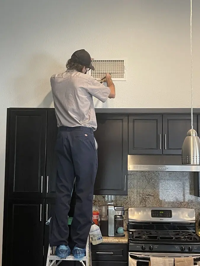 Technician inspecting an air vent during HVAC service in Florin